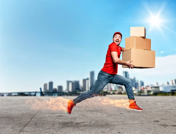 Courier with fiery feet has a lot of boxes to delivery. Emotional expression. — Stock Photo, Image