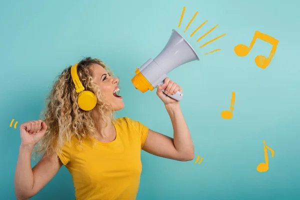 Perempuan bernyanyi dengan loudspeaker dan mendengarkan musik dengan headset. ekspresi gembira. latar belakang cyan — Stok Foto