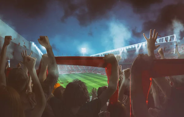 Escena de fútbol en el partido de noche con aficionados animadores en el estadio — Foto de Stock