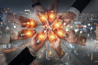 Bir lambayla aynı fikri paylaşan iş adamlarıyla takım çalışması ve beyin fırtınası konsepti. Başlangıcın konsepti