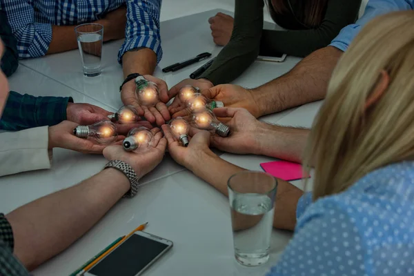 Trabajo en equipo y el concepto de lluvia de ideas con hombres de negocios que comparten una idea con una lámpara. Concepto de startup —  Fotos de Stock