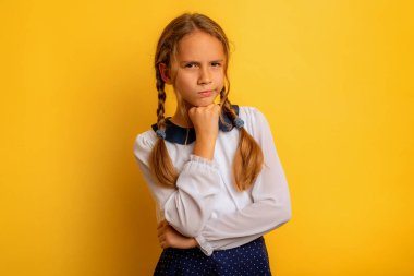 Genç öğrencinin bir konuda şüpheleri var. sarı arkaplan