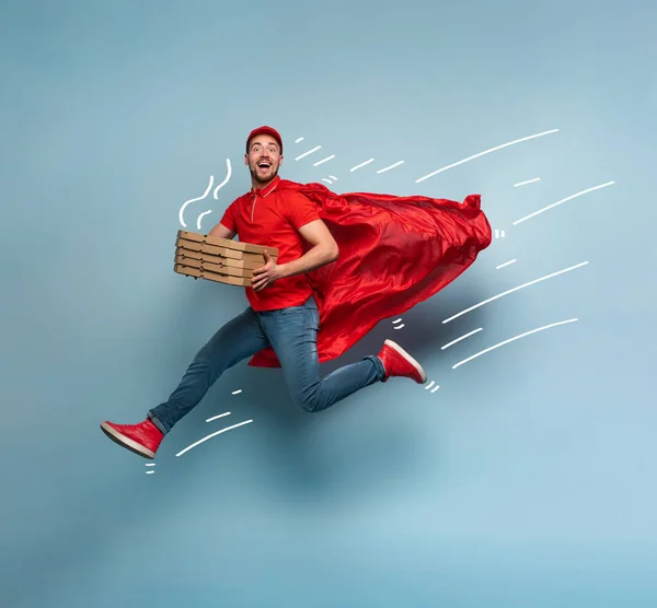 Deliveryman con pizzas actúa como un poderoso superhéroe. Concepto de éxito y garantía en el envío. Estudio de fondo cyan —  Fotos de Stock