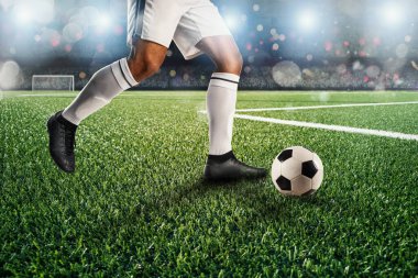 Futbol oyuncusu maç sırasında stadyumda futbol topuna vurmaya hazır..