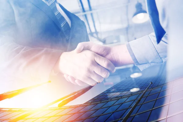 Two businessmen shake hands in agreement. Double exposure with light effect — Stock Photo, Image