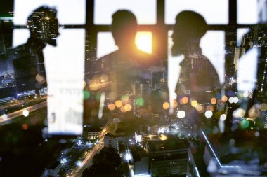 Geceleri ofiste birlikte çalışan iş adamları var. Takım çalışması ve ortaklık kavramı.