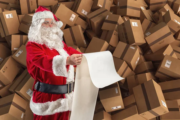 De kerstman zit vol met cadeautjes en dozen voor de levering. — Stockfoto