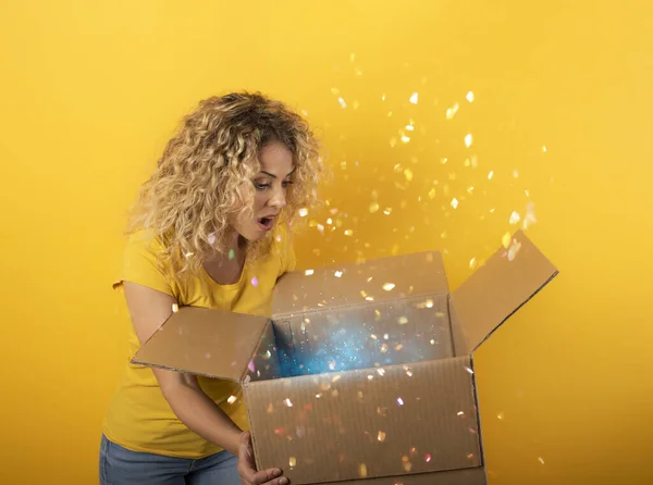 Menina feliz recebe um pacote de ordem loja on-line. Fundo amarelo. — Fotografia de Stock