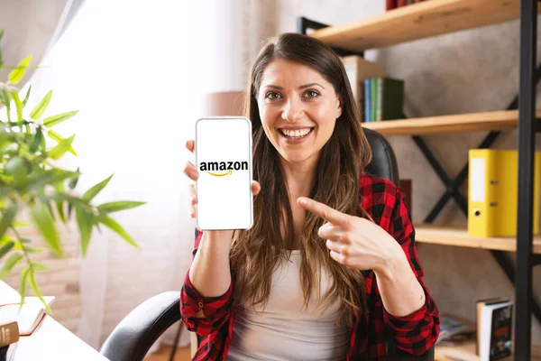 Mädchen kauft im Amazon-Shop mit ihrem Smartphone — Stockfoto