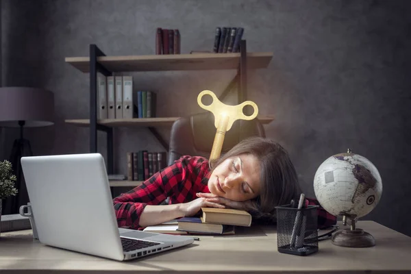 Chica estudiante cansada está durmiendo sobre sus libros en casa y él necesita un cargo —  Fotos de Stock