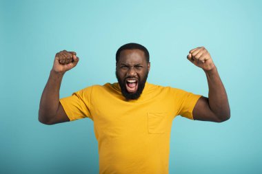 Çocuk bir şey kazanıyor. Şaşırmış ve şaşırmış yüz ifadesi. Açık mavi arkaplan