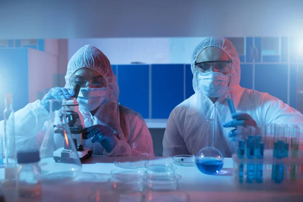 Doctor in the laboratory analyzes samples under a microscope. Pharmaceutical treatment concept. — Stock Photo, Image