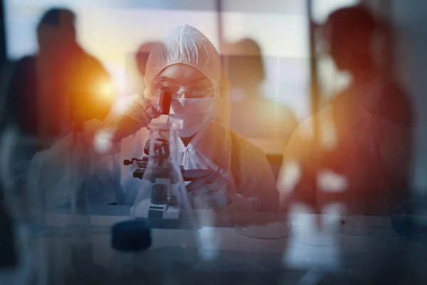 O médico do laboratório analisa amostras ao microscópio. Conceito de tratamento farmacêutico. — Fotografia de Stock