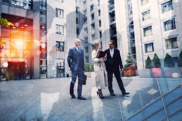 İş adamları ofisin dışında yürüyüp konuşuyorlar. Takım çalışması kavramı