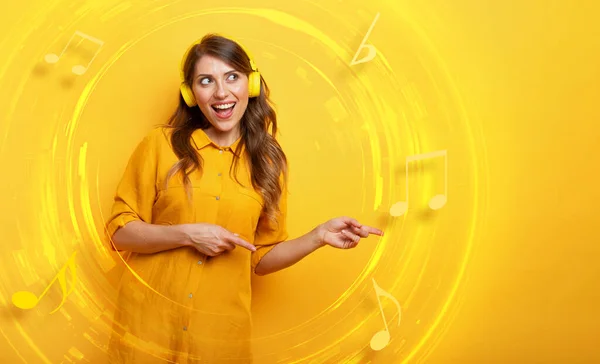 Dívka se žlutým sluchátkem poslouchá hudbu a tance. emocionální a energický výraz. — Stock fotografie