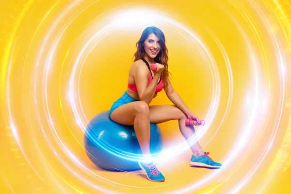 Entrena chicas con manillar y pelota de gimnasia. fondo de color amarillo —  Fotos de Stock