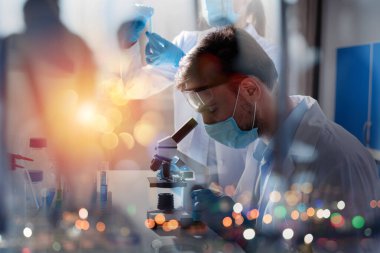 Laboratuvardaki doktor örnekleri mikroskop altında analiz ediyor. İlaç tedavisi konsepti.