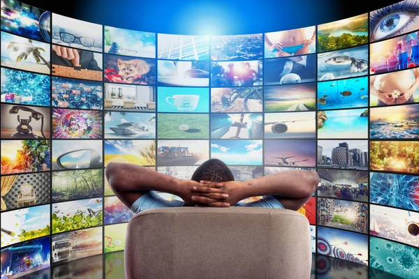 Homem se diverte assistindo a um filme e relaxando em uma poltrona. Conceito de entretenimento e streaming de tv. — Fotografia de Stock