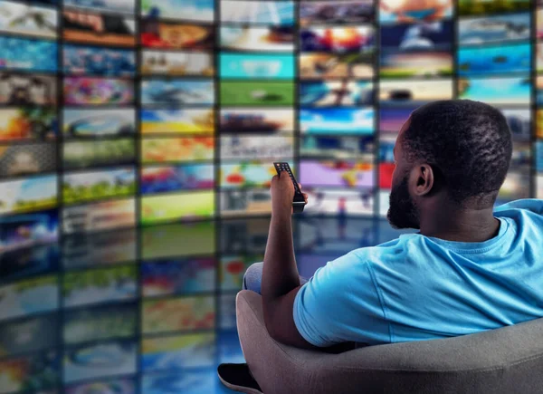 Ο άνθρωπος διασκεδάζει βλέποντας μια ταινία. Έννοια της ψυχαγωγίας και streaming tv. κόκκινο φόντο — Φωτογραφία Αρχείου
