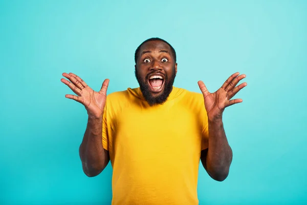 El hombre está sorprendido y emocionado por algo. antecedentes de cyan — Foto de Stock