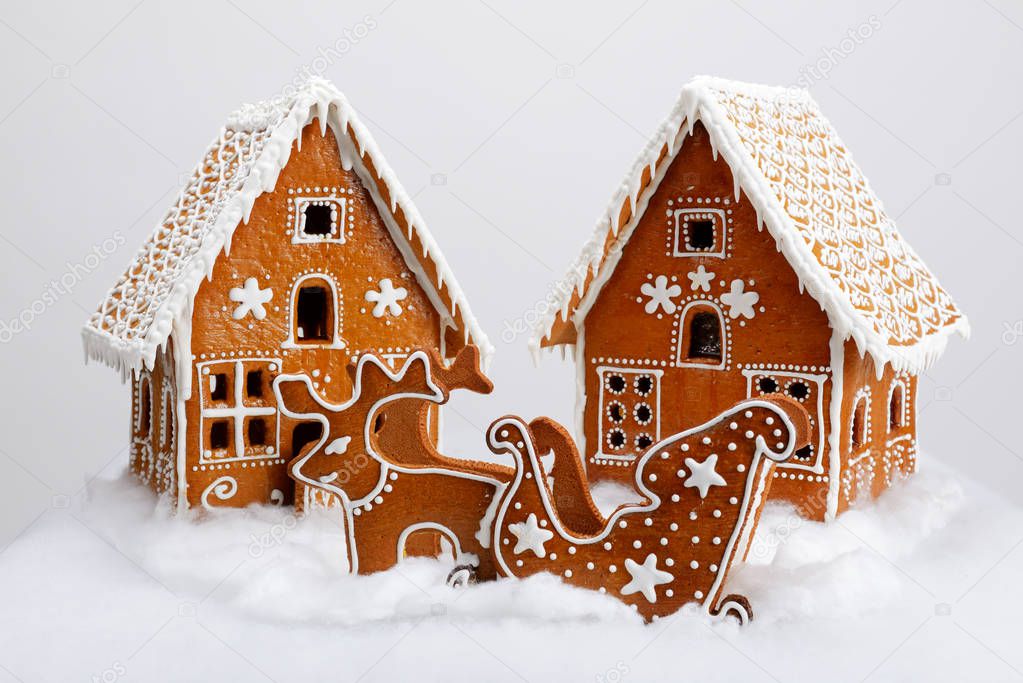 The hand-made eatable gingerbread houses, reindeer and cart with snow decoration