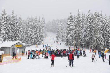 BUKOVEL, UKRAINE - 25 ARALIK: kayakçılar Bukovel kayak merkezinde bir asansör bekliyor. 25 Aralık 2018 tarihinde Bukovel, Ukrayna 'da 68 km pisti bulunan Ukrayna' nın en büyük kayak merkezidir.
