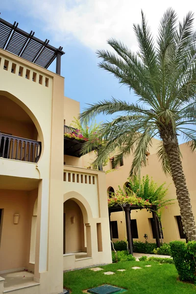 La villa de estilo árabe con césped verde y palmera en hotel de lujo, Fujairah, Emiratos Árabes Unidos — Foto de Stock