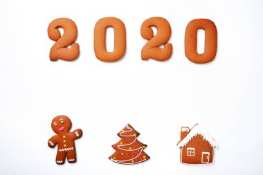 El yapımı yenebilir zencefilli 2020 yazıt, küçük adam, ev ve beyaz arka plan üzerinde Yeni Yıl ağacı