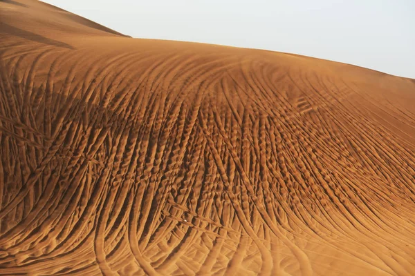 O deserto durante o pôr do sol e off-road carros pneus pisos, Dubai, Emirados Árabes Unidos — Fotografia de Stock