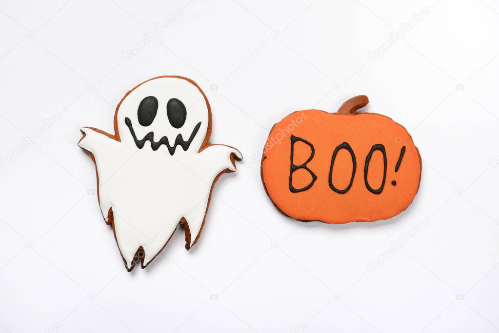 The hand-made eatable gingerbread Halloween ghost and pumpkin with boo inscription on white background