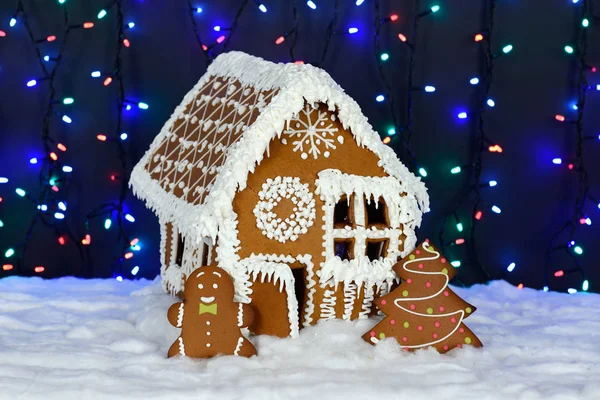 Имбирный домик ручной работы, маленький человечек, новогодняя елка, снежное убранство, подсветка гирлянды — стоковое фото
