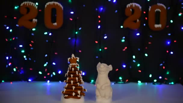 手作りの食べられるジンジャーブレッドハウス マウス 2020年のシンボル 新年の木 雪の装飾 花輪の背景照明 — ストック動画
