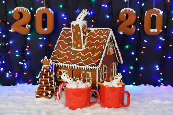 手工制作的可食用姜饼屋，棉花糖小人，年树，2020年铭文，雪装饰，花环背景照明 — 图库照片