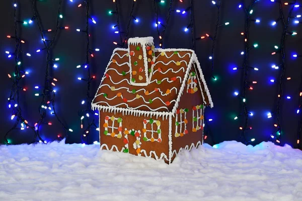 The hand-made eatable gingerbread house, snow decoration, garland background illumination — Stock Photo, Image