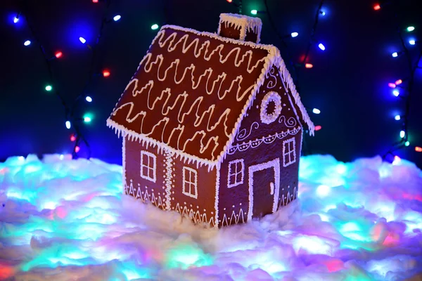 Den handgjorda ätbara pepparkakshus, snödekoration, Garland snö och bakgrundsbelysning — Stockfoto