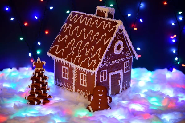 The hand-made eatable gingerbread house, New Year tree, little man, snow decoration, garland snow and background illumination — Stock Photo, Image