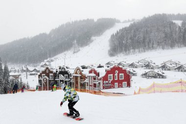 BUKOVEL, UKRAINE - 25 ARALIK: Kayakçılar ve kar sınırları Bukovel kayak merkezinin yamacında. 25 Aralık 2018 tarihinde Bukovel, Ukrayna 'da 68 km pisti bulunan Ukrayna' nın en büyük kayak merkezidir.