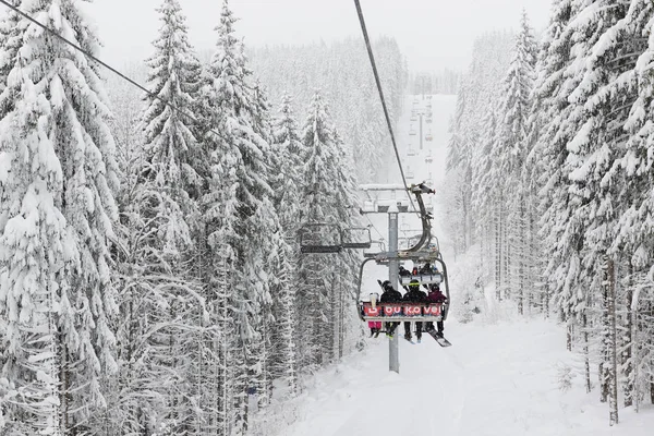 BUKOVEL, UKRAINE - 25. DEZEMBER: Die Skifahrer befinden sich auf einer Seilbahn im Skigebiet Bukovel. Es ist das größte Skigebiet in der Ukraine mit 68 km Pisten am 25. Dezember 2018 in Bukovel, Ukraine — Stockfoto