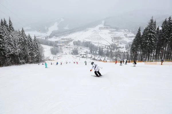 BUKOVEL, UKRAINE - 25 ARALIK: Kayakçılar ve kar sınırları Bukovel kayak merkezinin yamacında. 25 Aralık 2018 tarihinde Bukovel, Ukrayna 'da 68 km pisti bulunan Ukrayna' nın en büyük kayak merkezidir. — Stok fotoğraf