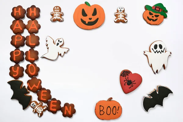 Die handgefertigten essbaren Lebkuchen-Halloween-Inschrift, Kürbisse, Geister und Skelette auf weißem Hintergrund — Stockfoto