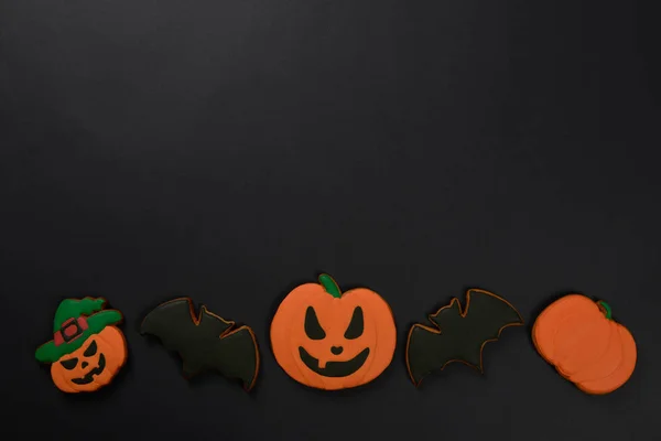 The hand-made eatable gingerbread Halloween pumpkins and bats on black background — Stock Photo, Image