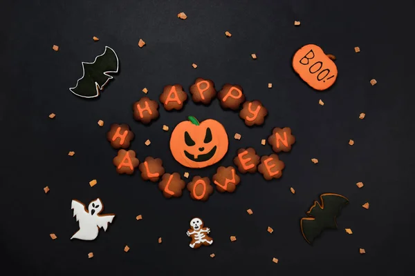 Ręcznie wykonany jadalnych Gingerbread Halloween napis, dynia, duchy, nietoperz i sceletons na czarnym tle — Zdjęcie stockowe