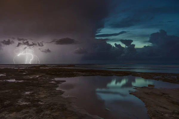 Storm weather with lightning on sea beach