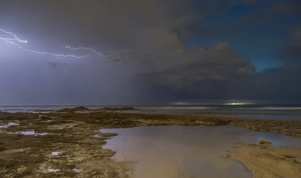 Storm weather with lightning on sea beach