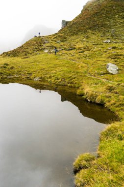 Dağ bulutlarında yağmurlu bir gün ve yol üzerinde yeşil tepeler