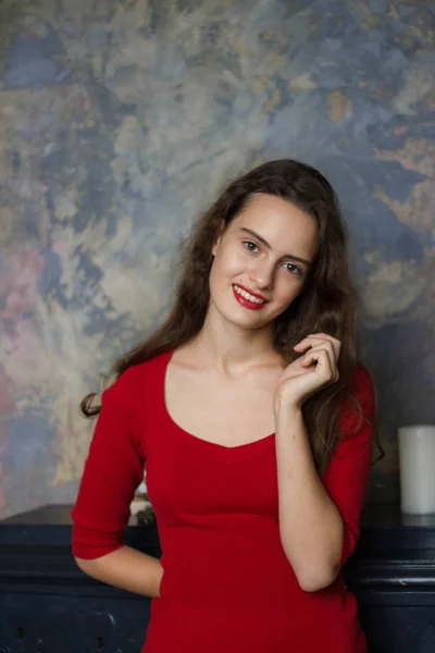 暗い背景に赤いドレスを着て幸せな魅力的な若い女の子の肖像画 — ストック写真