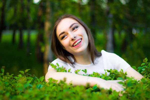 緑の葉、真夏の野外の背景に美しい若い女性の肖像画。緑の葉の間で立っている笑顔自然美人. — ストック写真