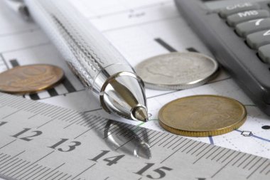 Para, hesap makinesi, grafik ve kalem ile mali geçmiş.