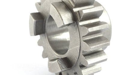 Beyaz zemin üzerinde bir metal dişli.