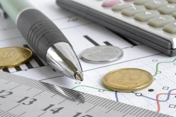 Para, hesap makinesi, grafik ve kalem ile mali geçmiş.